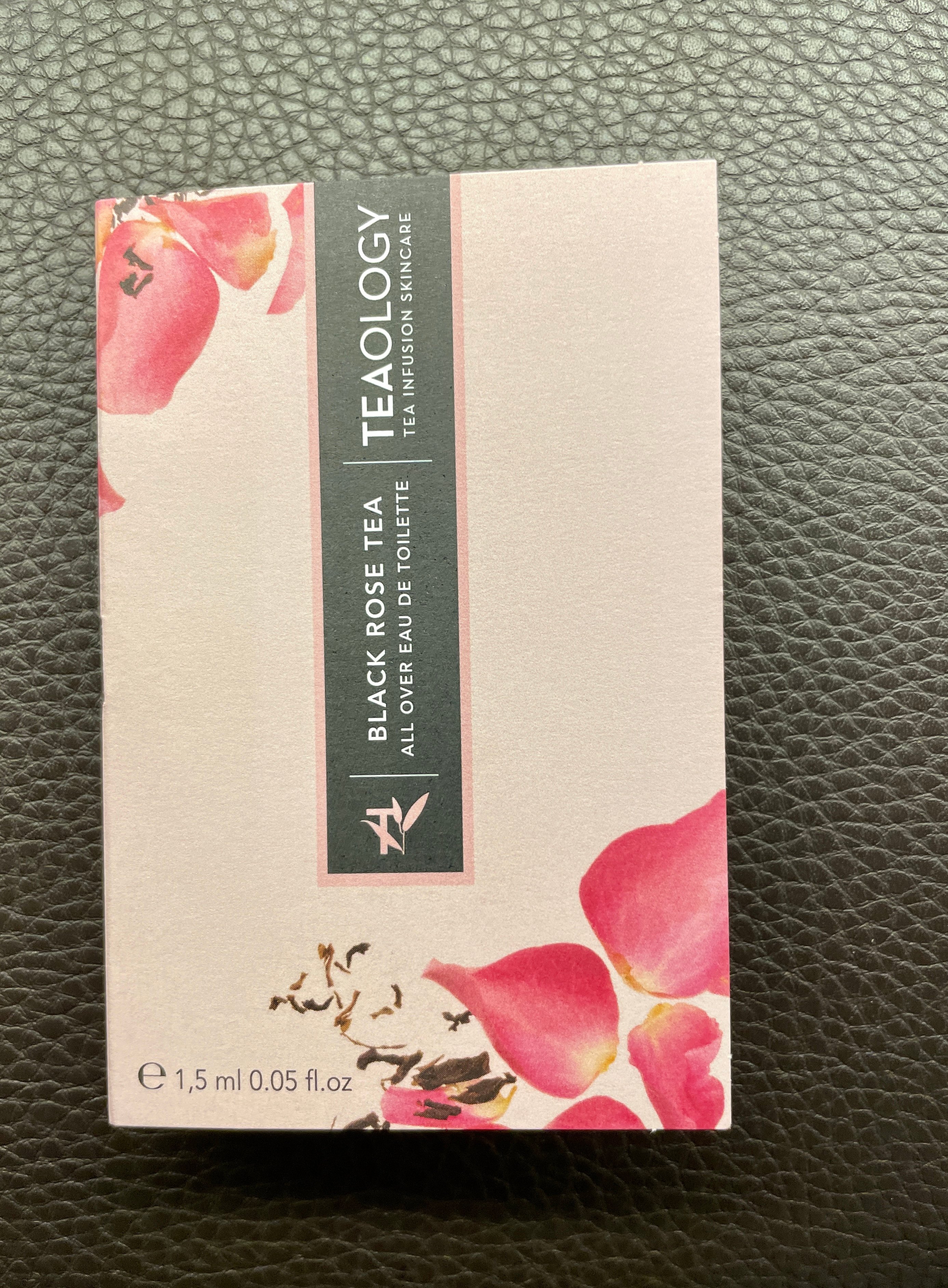 Schachtel mit schwarzem Rosentee-Duft von Teaology, 1,5 ml, auf schwarzem Lederhintergrund.